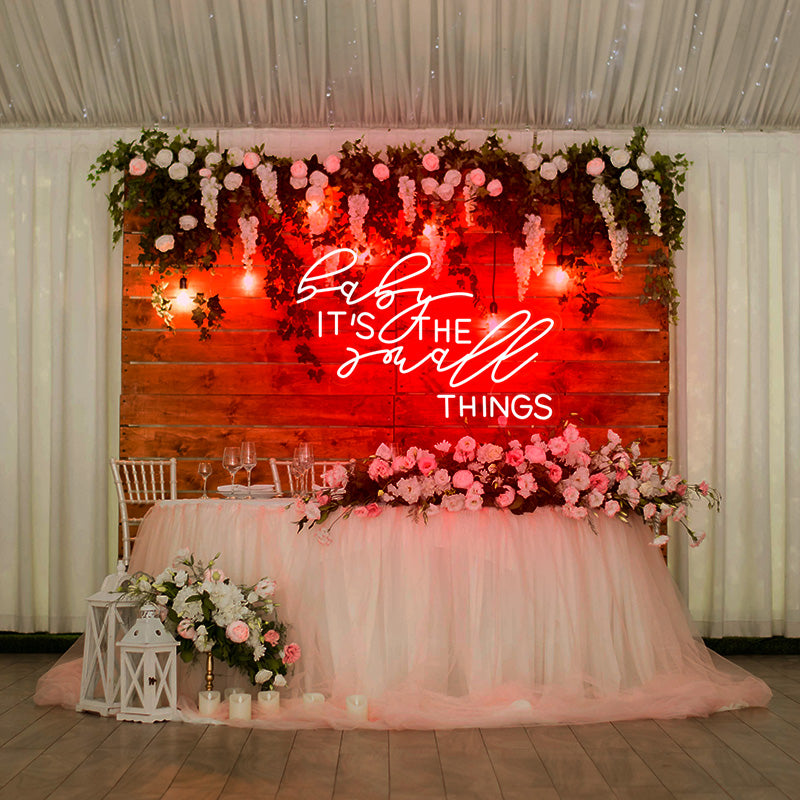 baby it's the small things neon sign in red installed on wedding table backdrop. Neon sign available online at Neon Partys. 